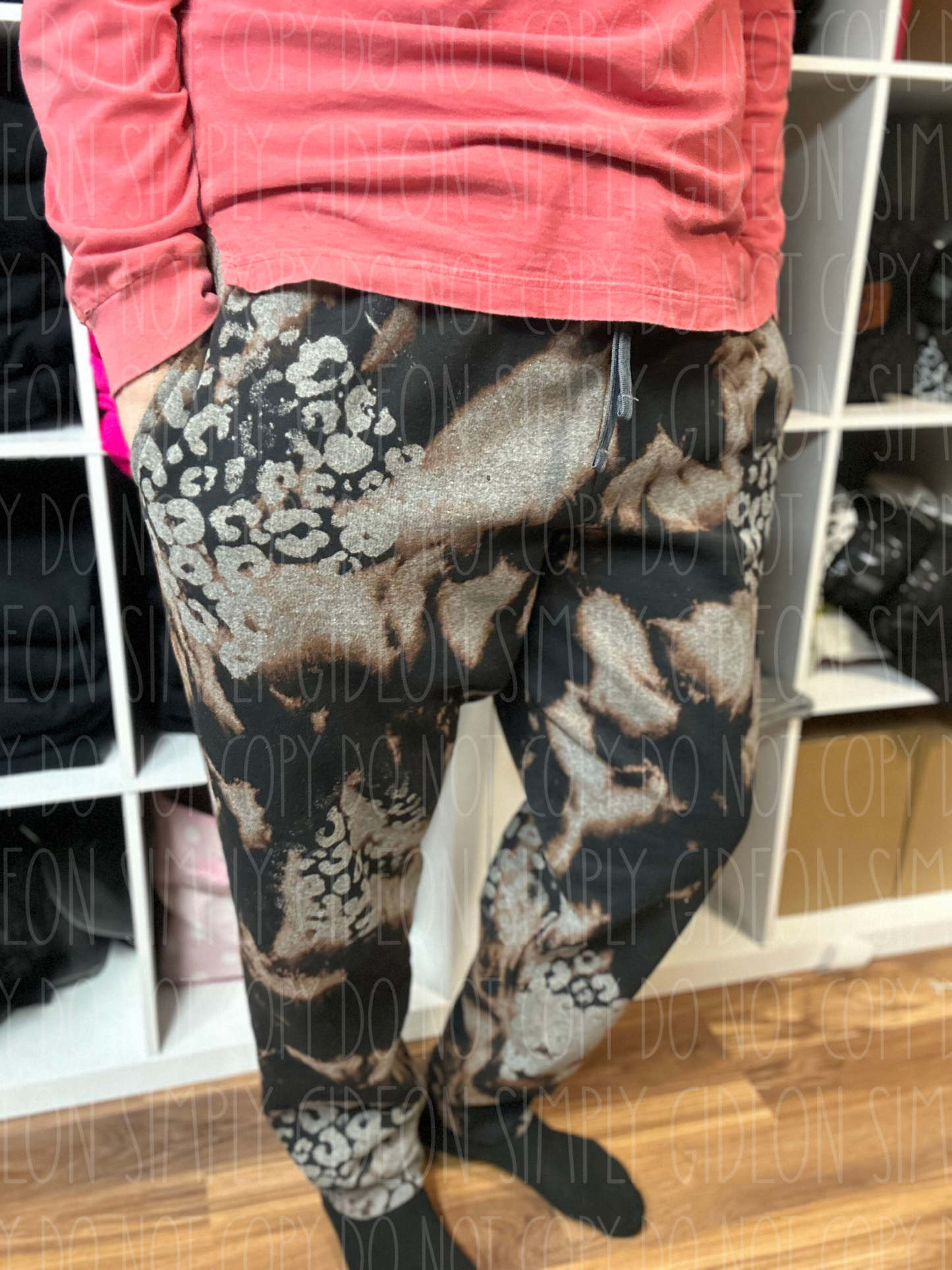 A pair of black and grey acid wash joggers with leopard print patches